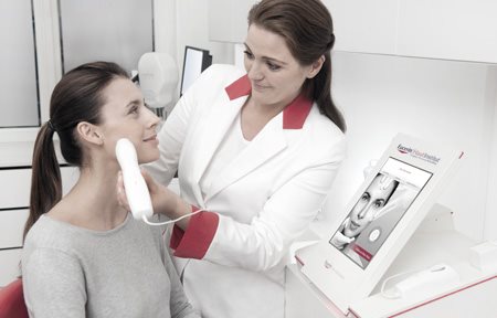 Dermatlogist using Skin Code Reader on woman´s face