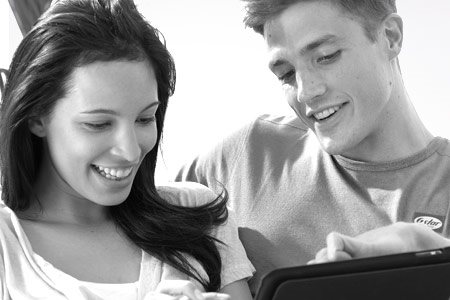 Couple on a couch checking on a tablet