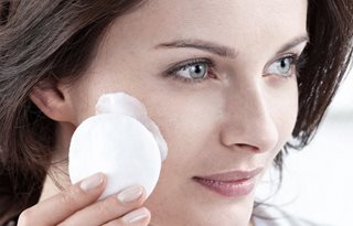 Woman applies Cleansing Milk on a cotton pad