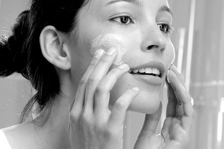 Woman appliying cream on her face
