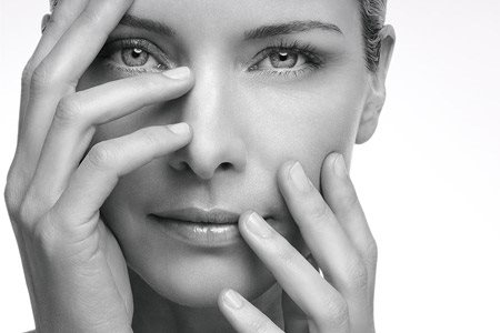 Woman holding up her hands in front of her face. 