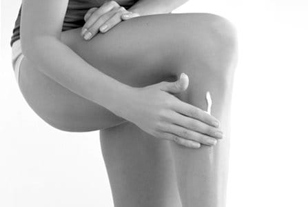 Woman touching her left leg