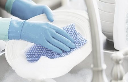 Hands with gloves washing dishes