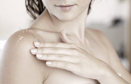 Woman with wet skin touching ger shoulder
