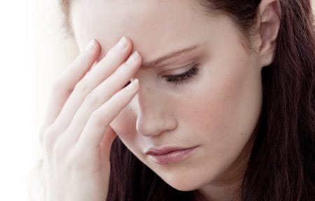 Woman in a stressed pose, one hand on her forehead.